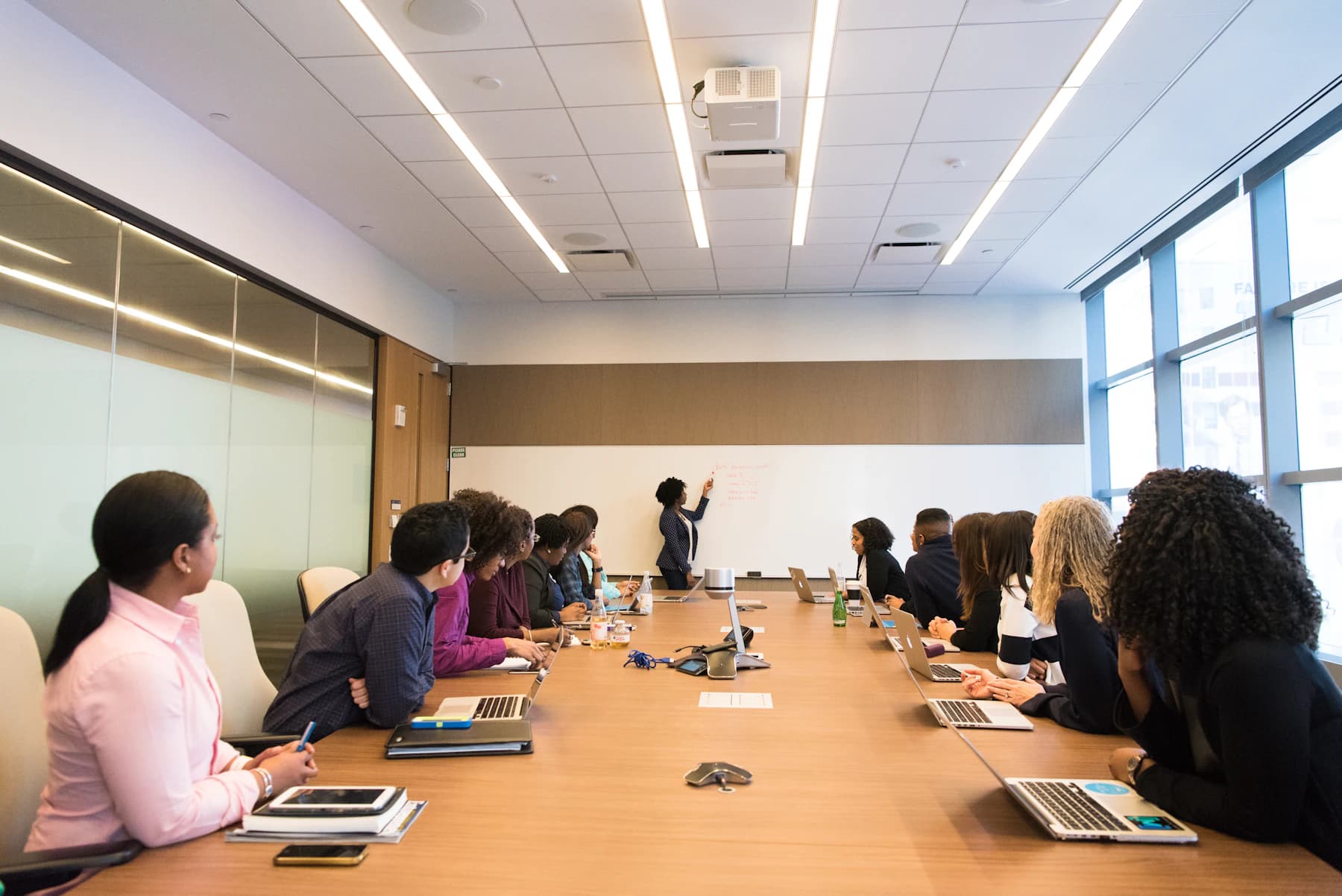 A leadership team listening to a facilitator in a meeting room